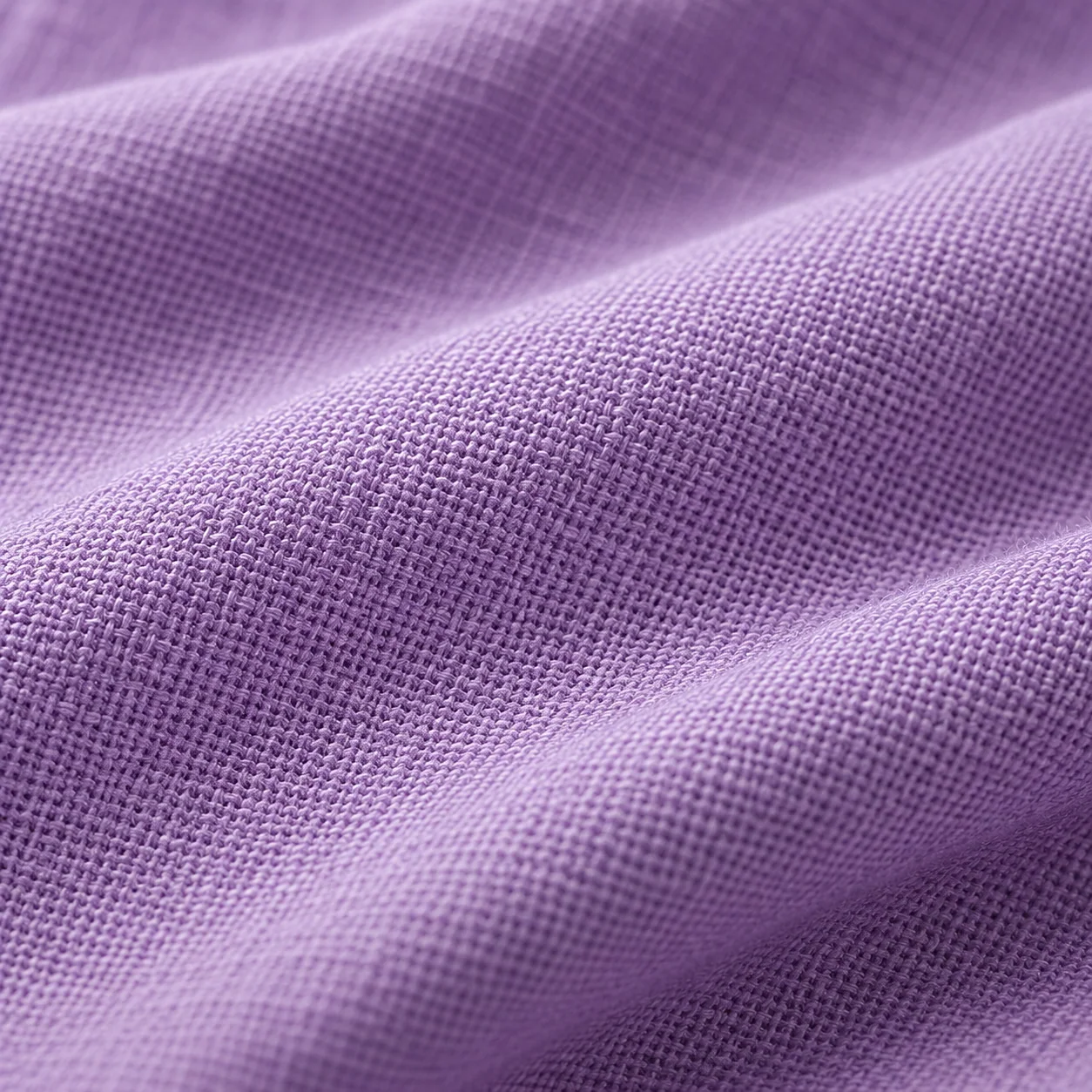 Close-up of crossing yarns in lavender woven fabric.